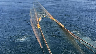 Ein Schleppnetz hinter einem Fischereischiff