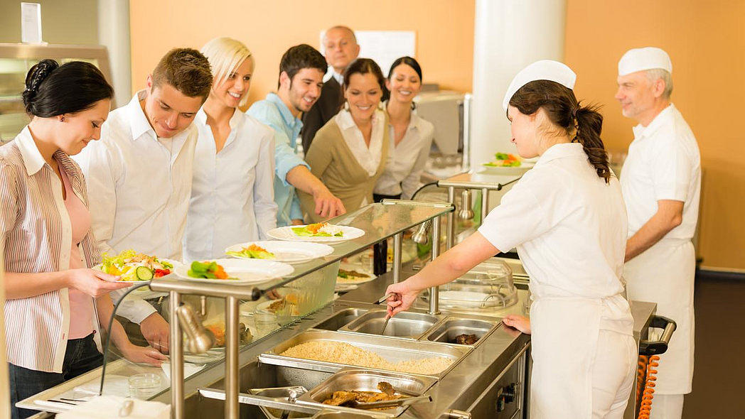 Menschen an der Essensausgabe in einer Kantine Menschen an der Essensausgabe in einer Kantine