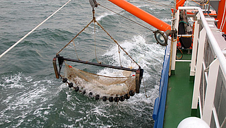 Eine Baumkurre auf einem Fischerboot wird zu Wasser gelassen